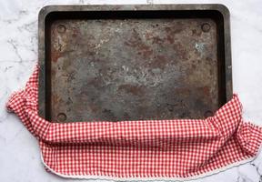 empty rectangular iron baking sheet on white marble table, photo