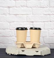 white cardboard box with pizza and disposable paper cups with coffee in holder photo