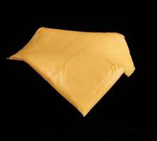 square piece of cheddar cheese isolated on black background, ingredients for sandwich photo