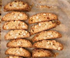 pieces of baked italian christmas biscotti cookies on a brown paper photo