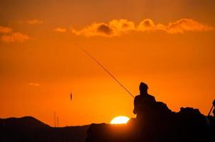 carrete de pesca sobre la puesta de sol foto