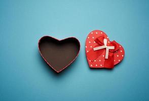 open empty red cardboard box in the form of a heart on a light blue background photo