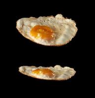 fried chicken egg with yolk isolated on black background photo