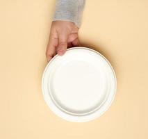 white paper disposable plate on a beige background, photo