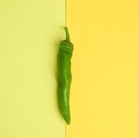 pod of green hot pepper on a yellow background photo