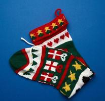 knitted brightly colored Christmas sock for gifts on a blue background photo