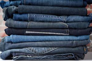 a pile of folded blue jeans different photo