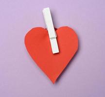 red paper heart pinned on a wooden clothespin photo