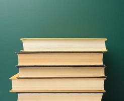 tablero escolar de tiza verde en blanco y pila de libros, foto
