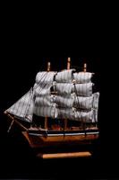 Miniature ship on black background photo