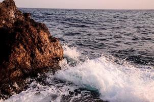 olas del mar golpeando rocas foto