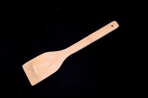 Wooden spoon on black background photo