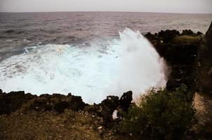 Large waves hitting rocks photo