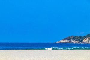 Beach sand blue water huge surfer waves Puerto Escondido Mexico. photo