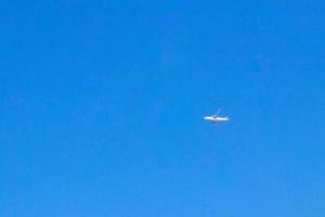 Plane flies over Puerto Escondido Mexico with blue sky. photo