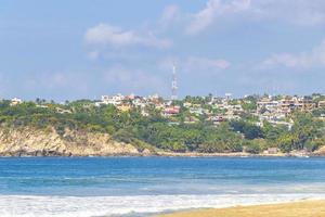 Beach sand blue water huge surfer waves Puerto Escondido Mexico. photo