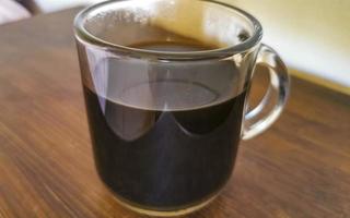 Glass cup of black coffee from Mexico on wooden background. photo