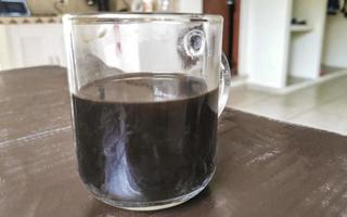 Taza de cristal de café negro de México sobre fondo de madera. foto