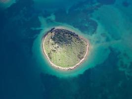 Aerial drone view of a small Island in Croatia with beautiful blue turquoise sea water. Travel and holidays destination. Amazing tourism in Croatia Islands. Black space for copy paste. Wallpaper. photo