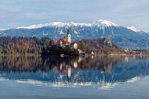 Sunrise winter scenery of magical Lake Bled in Slovenia. A winter tale for romantic experiences. Mountains with snow in the background. Church of the Mother of God on a little Island in the lake. photo