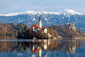 Sunrise winter scenery of magical Lake Bled in Slovenia. A winter tale for romantic experiences. Mountains with snow in the background. Church of the Mother of God on a little Island in the lake. photo