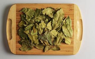 Spice Aromatic dry bay leaf. Aromatic spice for food. Background of dry bay leaf on a wooden kitchen board photo