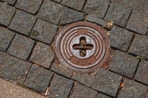 tapa de alcantarilla del sistema de gasoductos. una escotilla metálica masiva para el acceso a las comunicaciones de la ciudad en el pavimento. foto