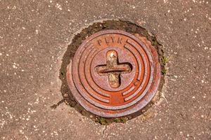 tapa de alcantarilla del sistema de gasoductos. una escotilla metálica masiva para el acceso a las comunicaciones de la ciudad en el pavimento. foto