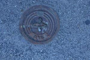 tapa de alcantarilla del sistema de gasoductos. una escotilla metálica masiva para el acceso a las comunicaciones de la ciudad en el pavimento. foto