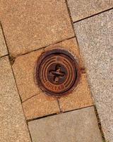 Manhole cover of the gas pipeline system. A massive metal hatch for access to city communications in the pavement. photo