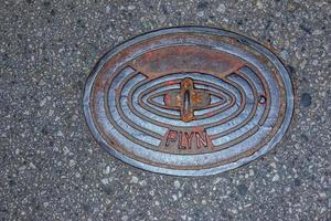 tapa de alcantarilla del sistema de gasoductos. una escotilla metálica masiva para el acceso a las comunicaciones de la ciudad en el pavimento. foto