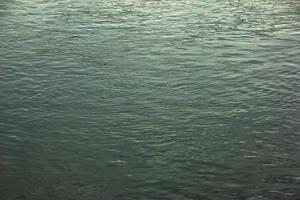 Background of the surface of the Danube river in a winter sunny day. Reflection of sun glare on the water surface with characteristic ripples. photo