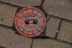 tapa de alcantarilla del sistema de gasoductos. una escotilla metálica masiva para el acceso a las comunicaciones de la ciudad en el pavimento. foto