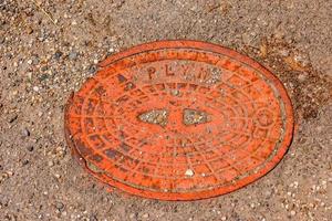 tapa de alcantarilla del sistema de gasoductos. una escotilla metálica masiva para el acceso a las comunicaciones de la ciudad en el pavimento. foto