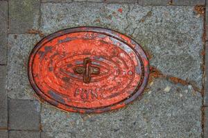 tapa de alcantarilla del sistema de gasoductos. una escotilla metálica masiva para el acceso a las comunicaciones de la ciudad en el pavimento. foto