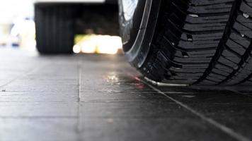 neumáticos abstractos de coches que acaban de limpiarse. estacionado en el piso de baldosas negras en el estacionamiento foto