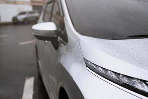 gota de lluvia llovizna en el parabrisas de cristal por la noche. detenga la calle del automóvil bajo la fuerte lluvia en la ciudad. conduzca el automóvil con cuidado, camino resbaladizo. enfoque suave. foto