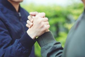 compañerismo mano apretando éxito confianza, concepto seguro. o primer plano de una mano de negocios entre dos colegas en parques. foto