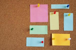 collection of colorful variety. paper note pad reminder sticky notes pin paper yellow on cork bulletin board photo