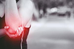 unhappy man suffering from Sport injury while exercise with Lower holding hands pain in the elbow. image black and white and highlighted in red color show muscle injury. health care or medical concept photo