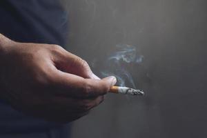 el mango masculino usa encendedores para fumar un cigarrillo. foto