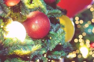 Closeup of bauble colorful variety hanging from a decorated christmas tree on blurred of lights with decorated tree, sparkling and bokeh background. copy space for your text. Christmas Tree Decoration photo