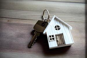 Real estate concept - Key ring and keys on white wooden background photo