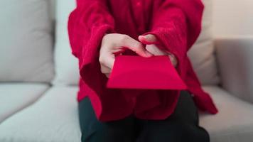mulher segurando envelope vermelho chinês, presente de dinheiro para feliz feriado do ano novo lunar video