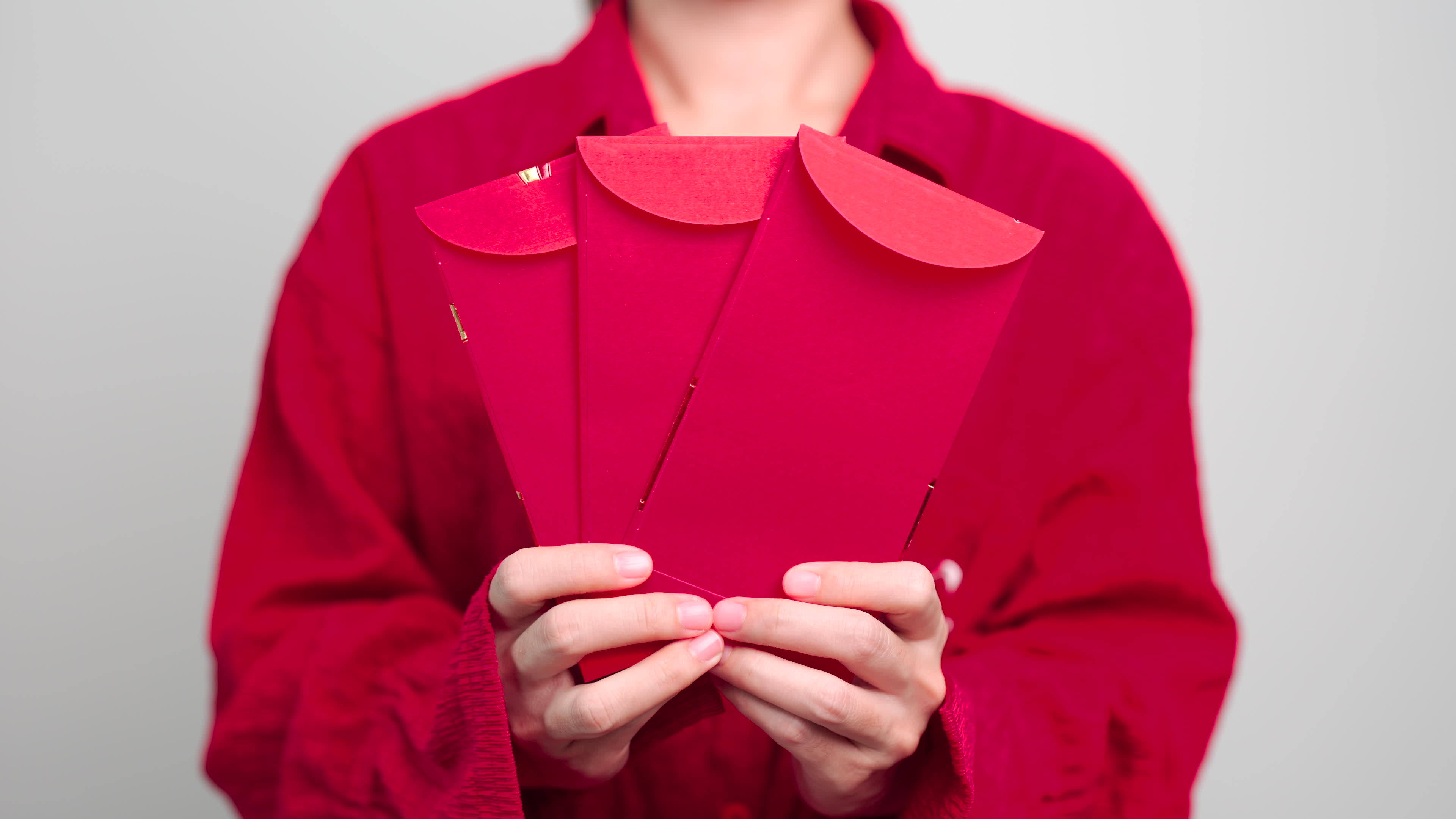 Woman holding Chinese red envelope, money gift for happy Lunar New Year 