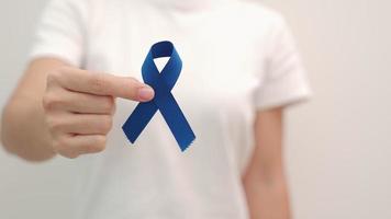 maart colorectale kanker bewustzijn maand, vrouw met donkerblauw lint voor het ondersteunen van mensen die leven en ziekte. gezondheidszorg, hoop en wereldkankerdagconcept video