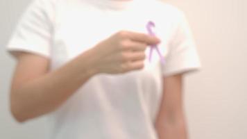 journée mondiale du cancer, 4 février. main de femme tenant un ruban violet lavande pour soutenir les personnes vivant et malades. concept de soins de santé et médical video