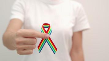 hand holding LGBTQ Rainbow ribbon for Support Lesbian, Gay, Bisexual, Transgender and Queer community and Pride month concept video