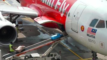 CHANGI, SINGAPORE NOVEMBER 25, 2018  - AirAsia Airbus 320 at uploading luggage onboard, Changi airport, Singapore. video