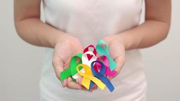 dia mundial do câncer, 4 de fevereiro. fitas coloridas para apoiar pessoas vivas e doentes. saúde, luta, dia de sobrevivência ao câncer médico e nacional, conceito de dia de conscientização do autismo video